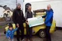 Councillor Richard Scott (left, with son Owen) and Councillor Jeff Trail (right) present a cheque to Roger Stokes of the Woodbury Local History Society.