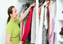 Woman arranging clothes at wardrobe