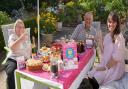 A family holding a Hopiscare coffee morning