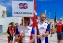 Des and Alison White carrying the flag at the closing ceremony