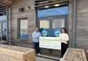 Joanna Towns, marketing manager at Barratt David Wilson Homes Exeter, presents a cheque to David Duignan outside the new premises of Charlie’s Beach School in Exmouth