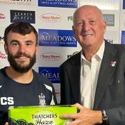 Exmouth Town's Callum Shipton receives his man of the match award from John Dibsdall