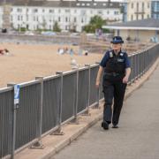 A police officer on Exmouth seafront - they will soon be backed up by community patrols