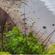 Exmouth Coastguard Team on the beach rescuing a dog