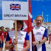 Des and Alison White carrying the flag at the closing ceremony