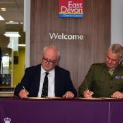 Cllr Paul Arnott (centre) signs the covenant