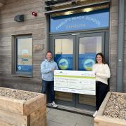 Joanna Towns, marketing manager at Barratt David Wilson Homes Exeter, presents a cheque to David Duignan outside the new premises of Charlie’s Beach School in Exmouth